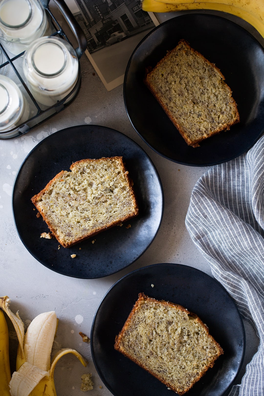 three slices of homemade banana bread on three black plates