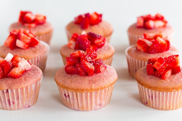 A process shot of filling strawberry cupcakes with fresh strawberries