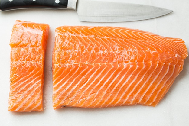 Cutting a side of salmon into fillets.