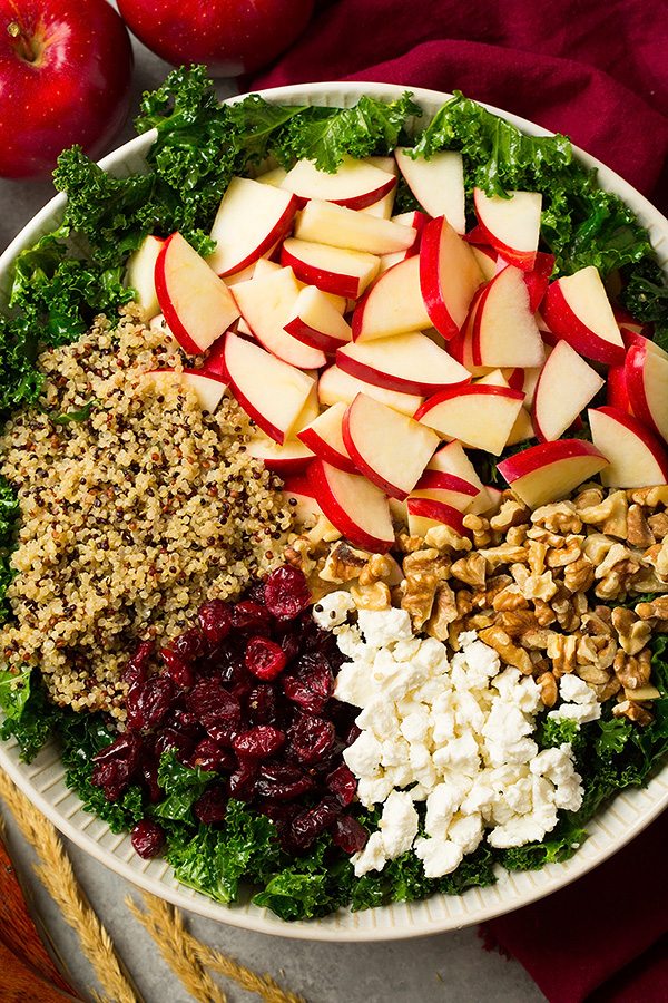 Kale salad ingredients in a salad bowl before tossing.