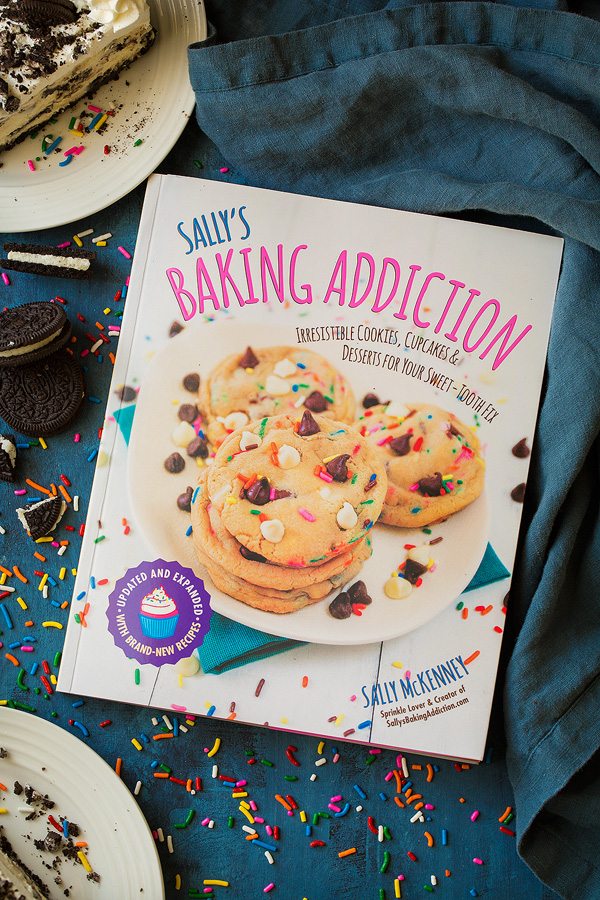 Sally's Baking Addiction Cookbook with recipe Oreo Cheesecake inside.