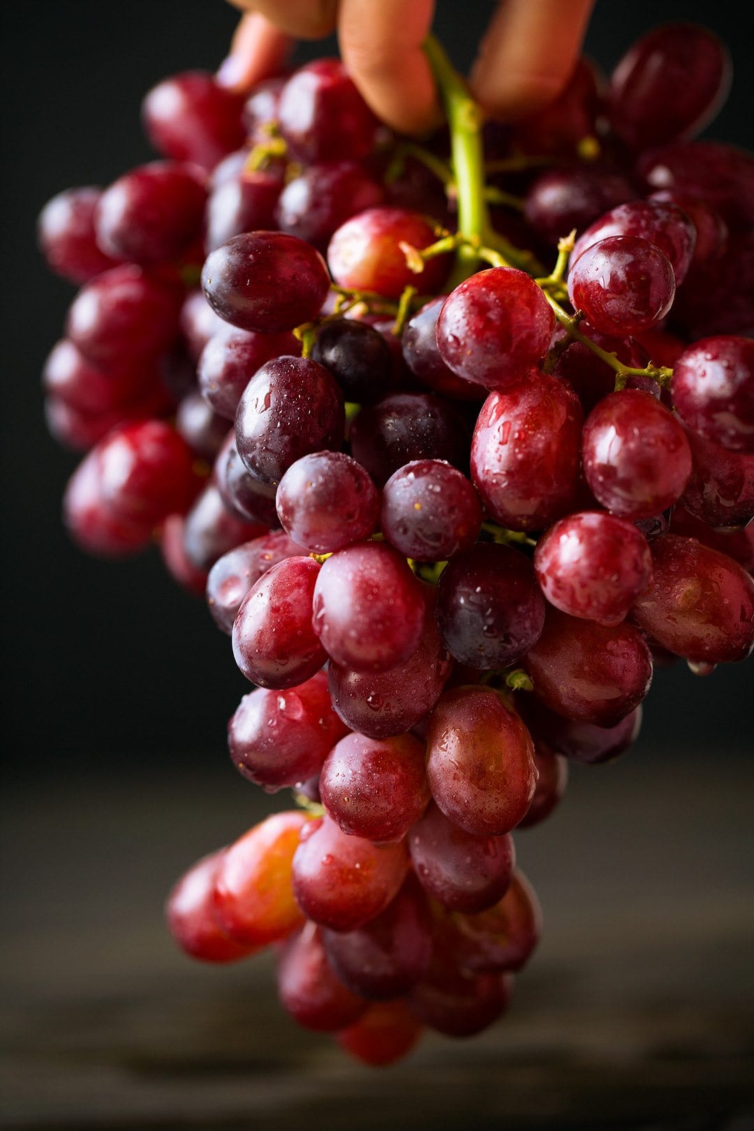 Close up image of red grapes dripping with water.
