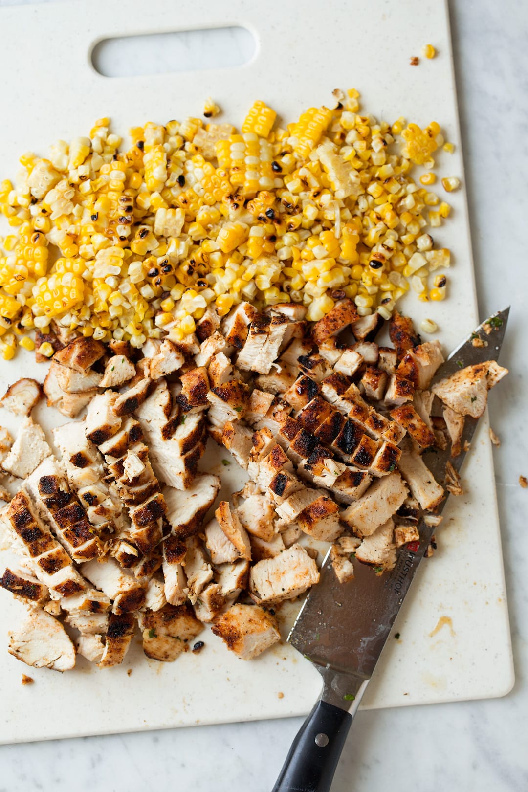 Ingredients for Grilled Chicken Tortilla Soup chopped up on a chopping board