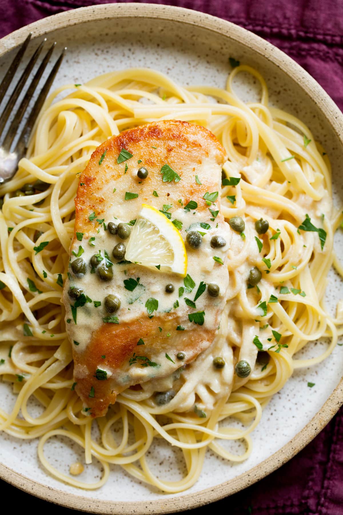 Chicken piccata served over fettucine pasta.