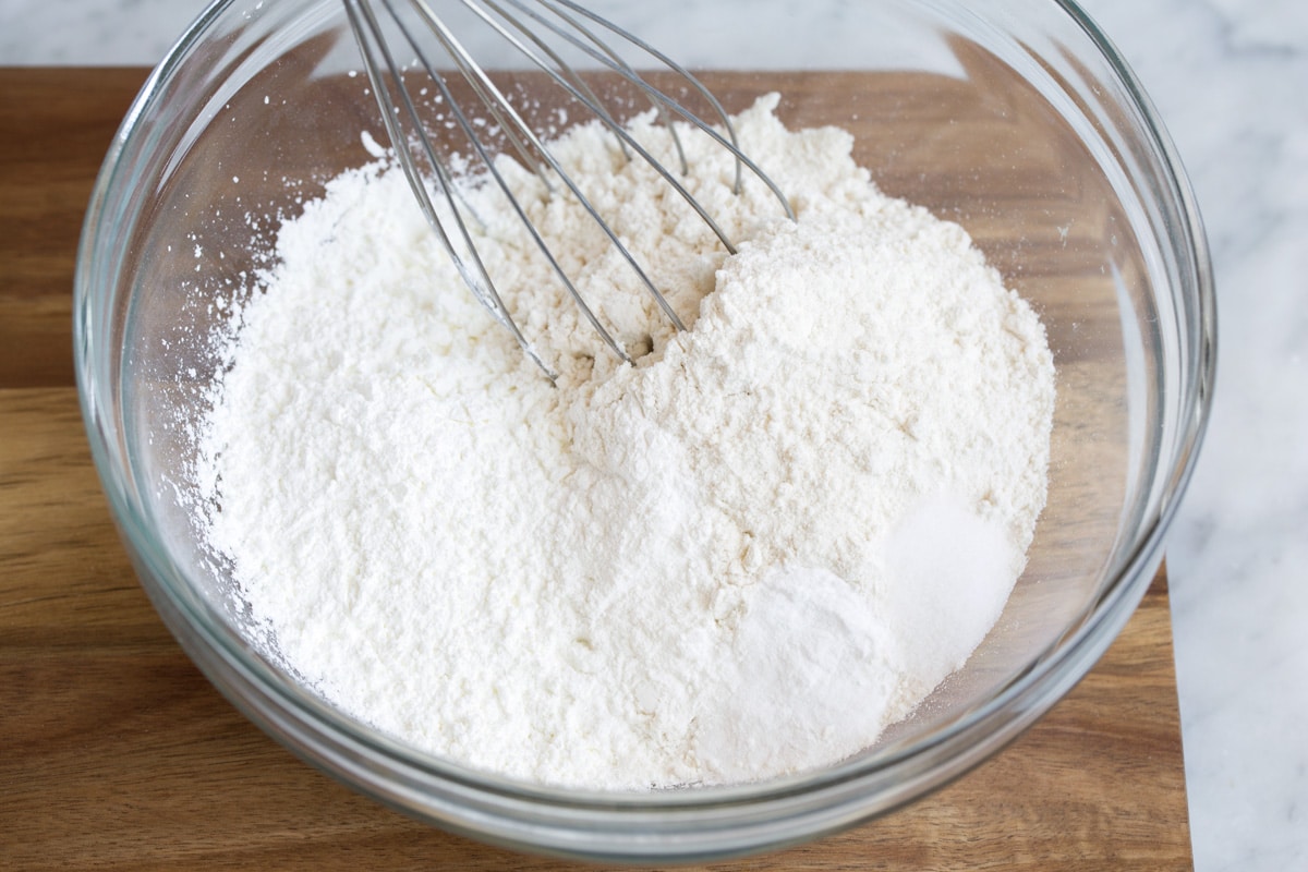 Showing how to make belgian waffle batter. Starting here by whisking dry ingredients in a glass mixing bowl.
