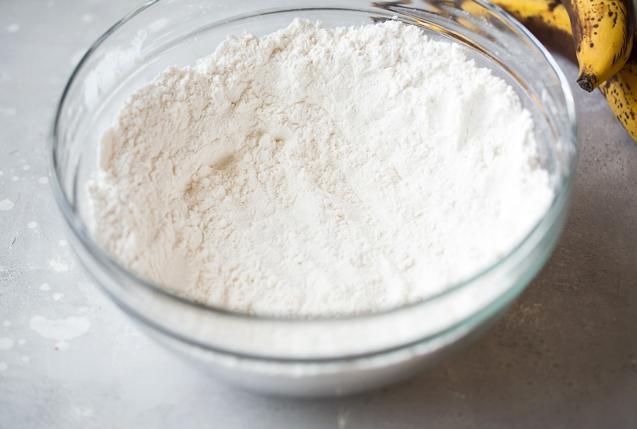 whisk dry ingredients for banana bread in a glass bowl