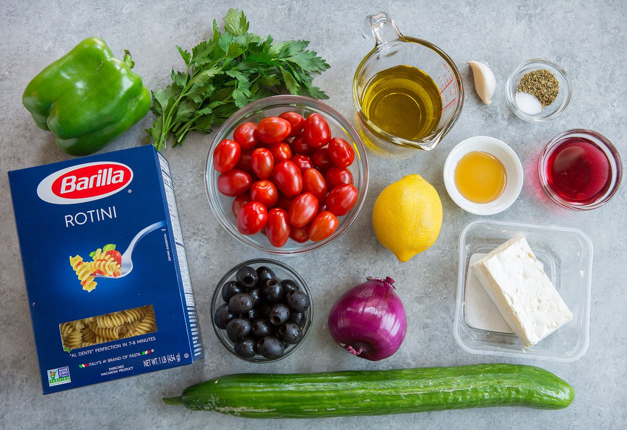 Greek Pasta Salad ingredients pasta bell pepper parsley tomatoes olives cucumber red onion lemon olive oil red wine vinegar basil oregano garlic honey feta