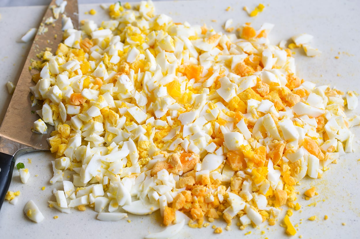 Chopping eggs on a cutting board into small pieces