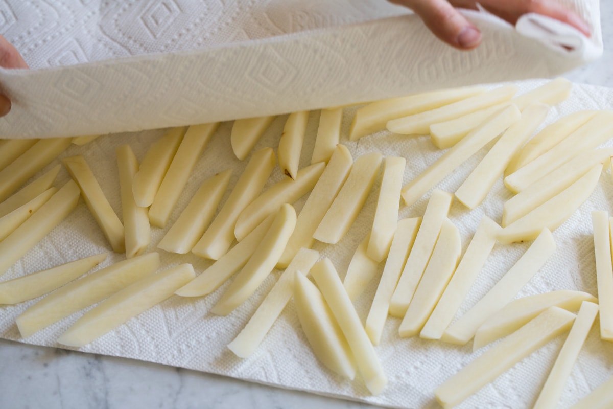 Drying potato sticks with paper towels.