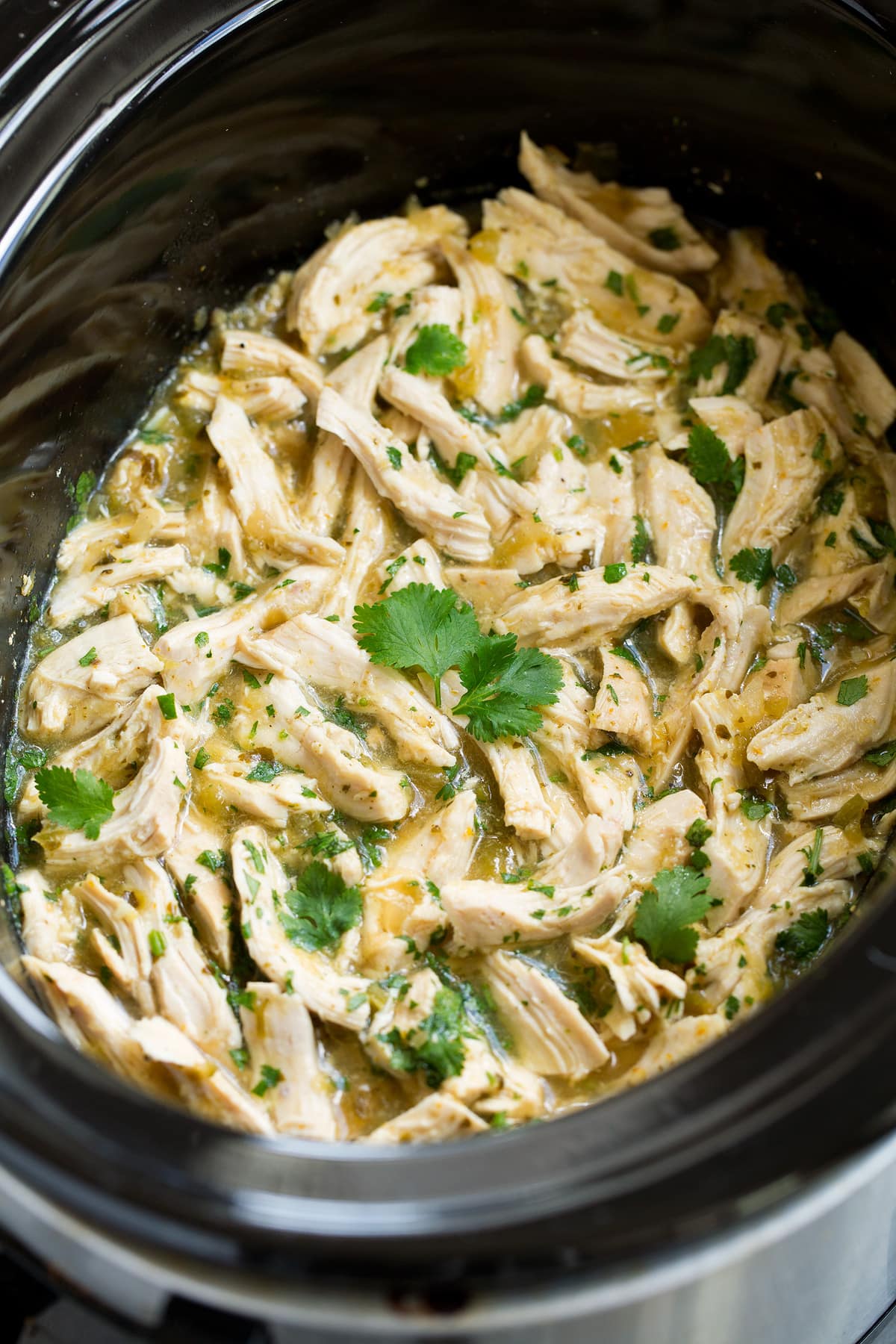 Shredded salsa verde chicken garnished with cilantro.