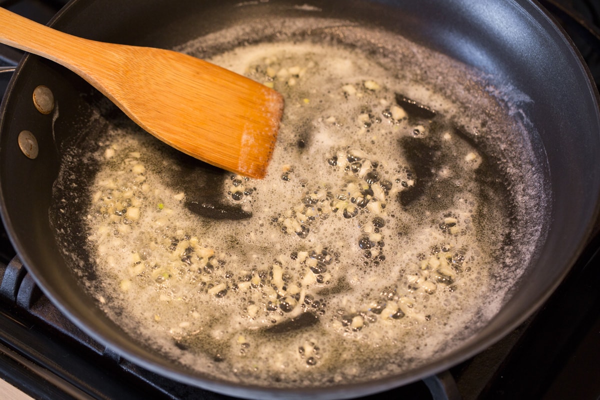 Melting butter and garlic in skillet.