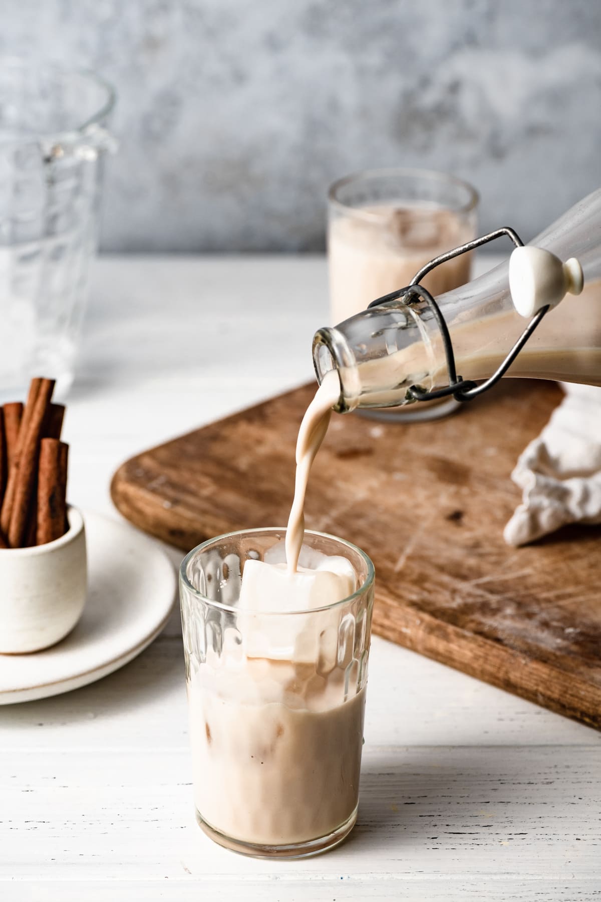 Pouring horchata into a cup with ice.