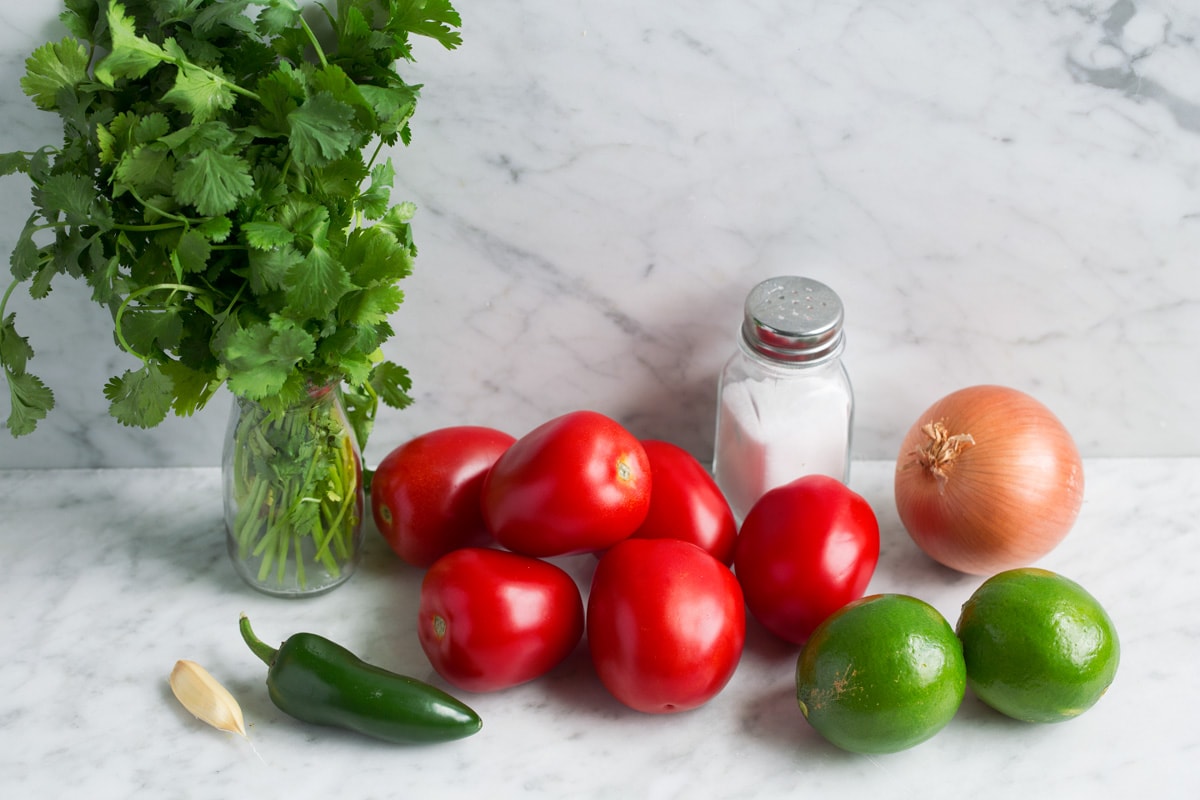 Pico de gallo ingredients: tomatoes, lime, yellow onion, jalapeno, garlic, salt and cilantro.