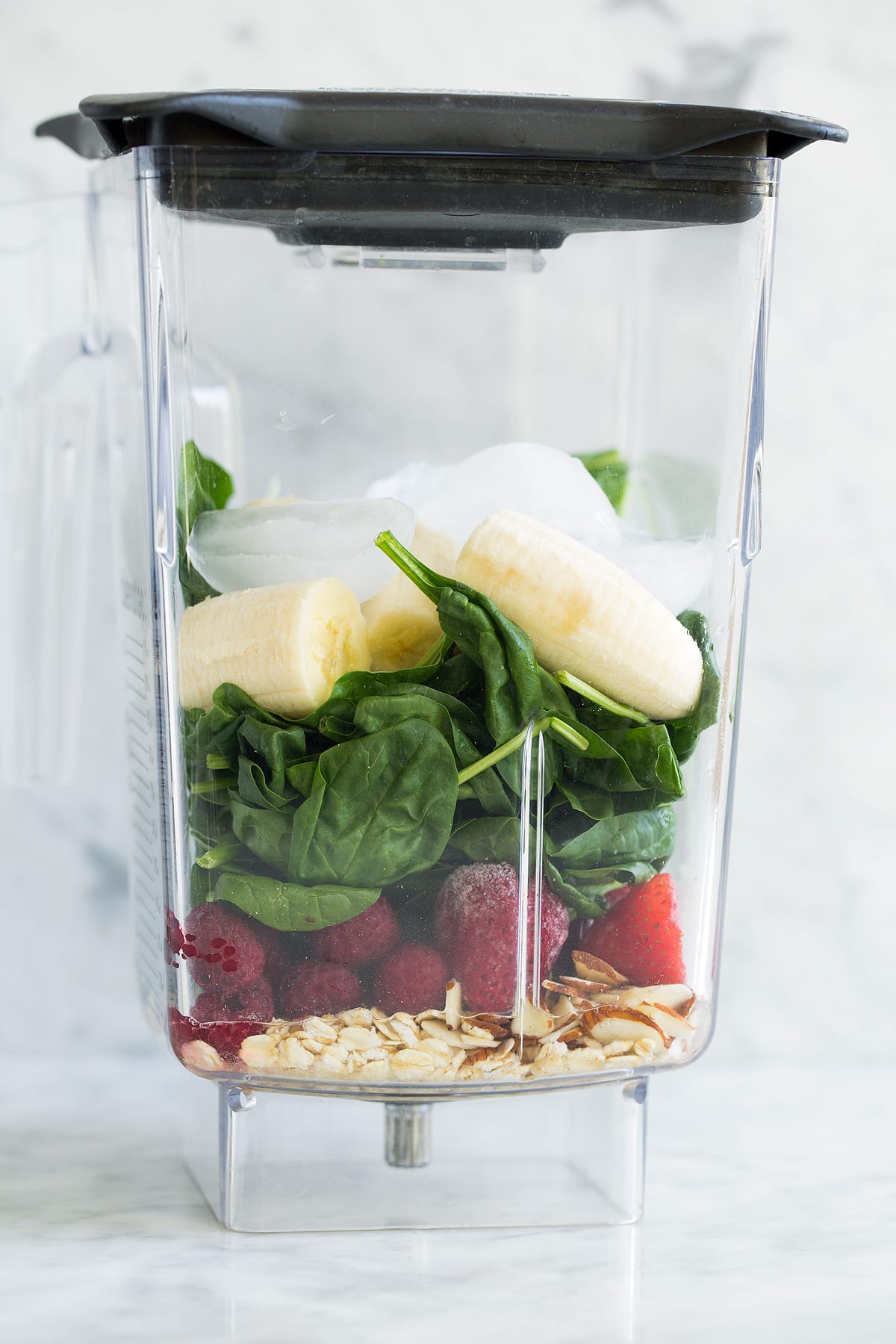 Green smoothie ingredients in a blender jar before blending.