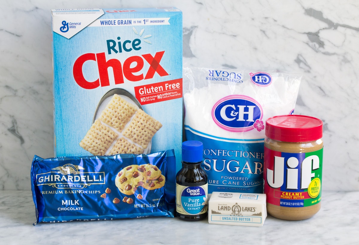 Ingredients needed to make puppy chow including chex cereal, powdered sugar, chocolate chips, peanut butter, vanilla and butter.