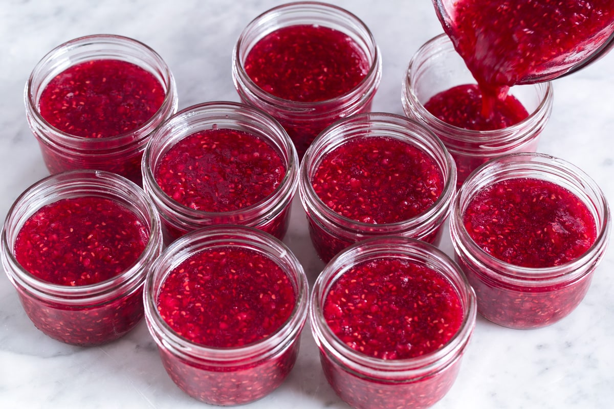 Pouring jam into glass jars.