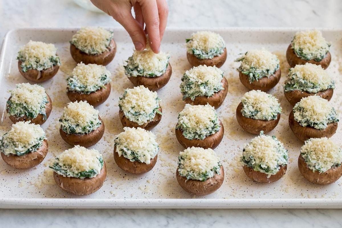 Topping stuffed mushrooms on baking sheet with panko topping.
