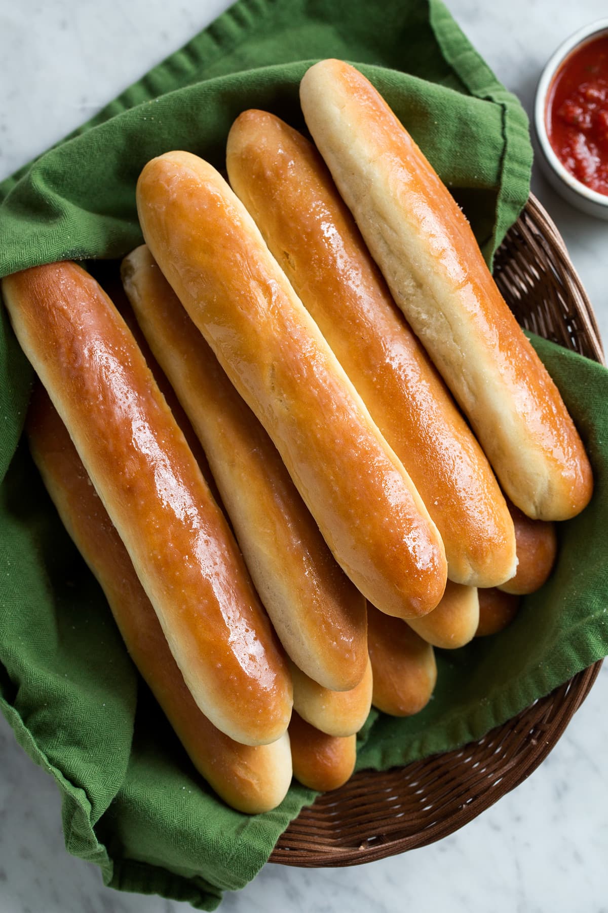 Overhead image of stack of breadsticks on basket.
