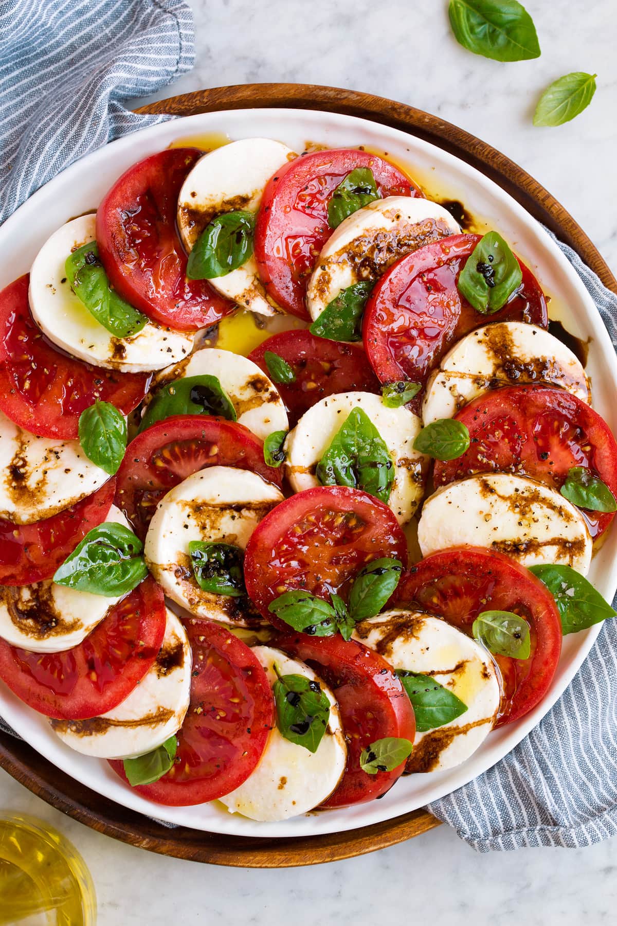 Overhead image of carpese salad with balsamic glaze on a white platter.