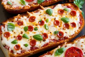 French Bread Pizza shown from a side angle on a baking sheet.