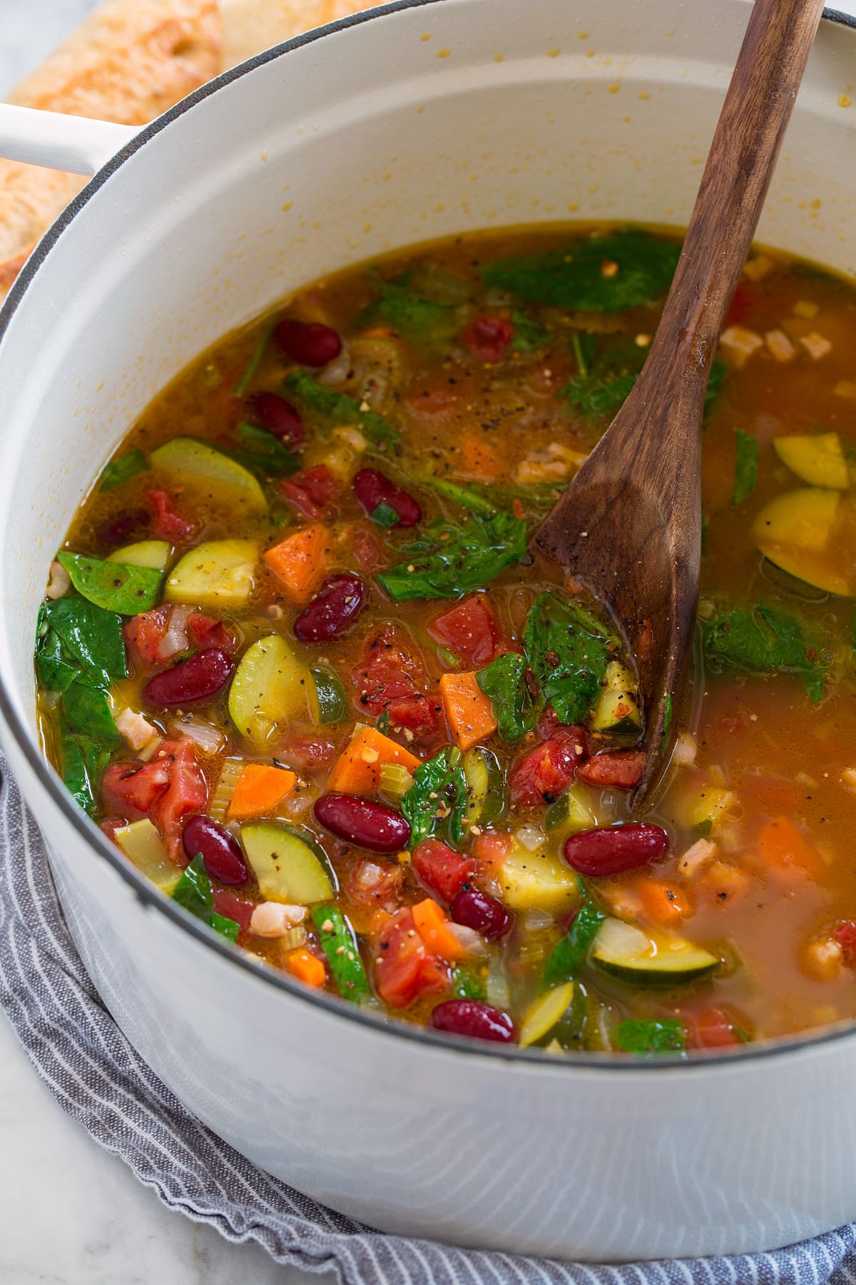 Pot full of minestrone soup shown from the side.