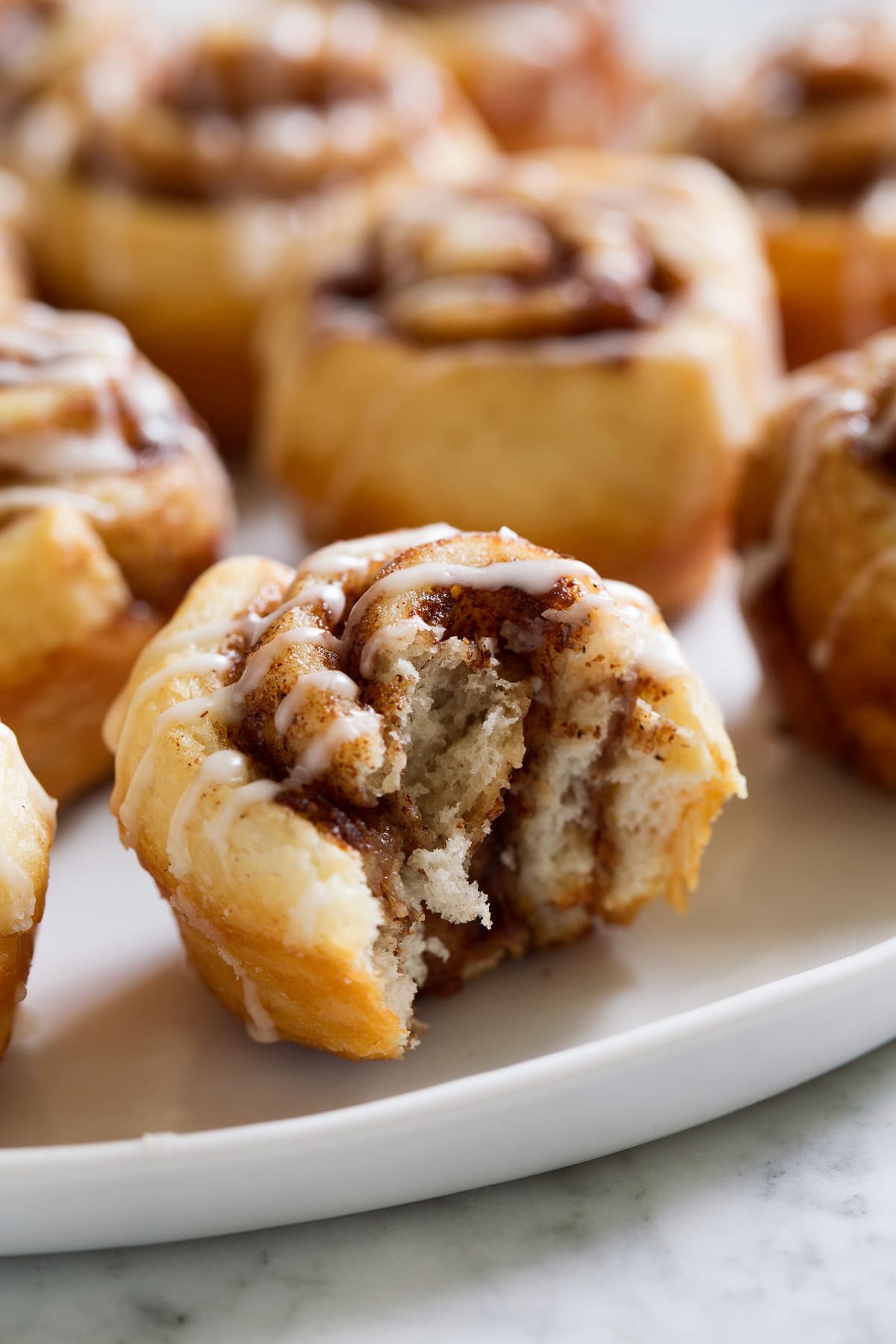 Image of mini cinnamon roll shown bitten into.