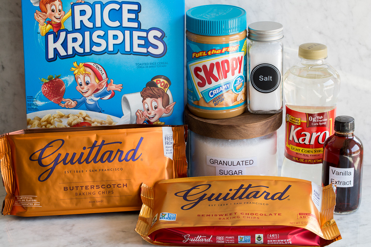 Image of ingredients used to make scotcheroos. Includes rice krispies cereal, peanut butter, sugar, salt, corn syrup, dark chocolate chips and butterscotch chips.