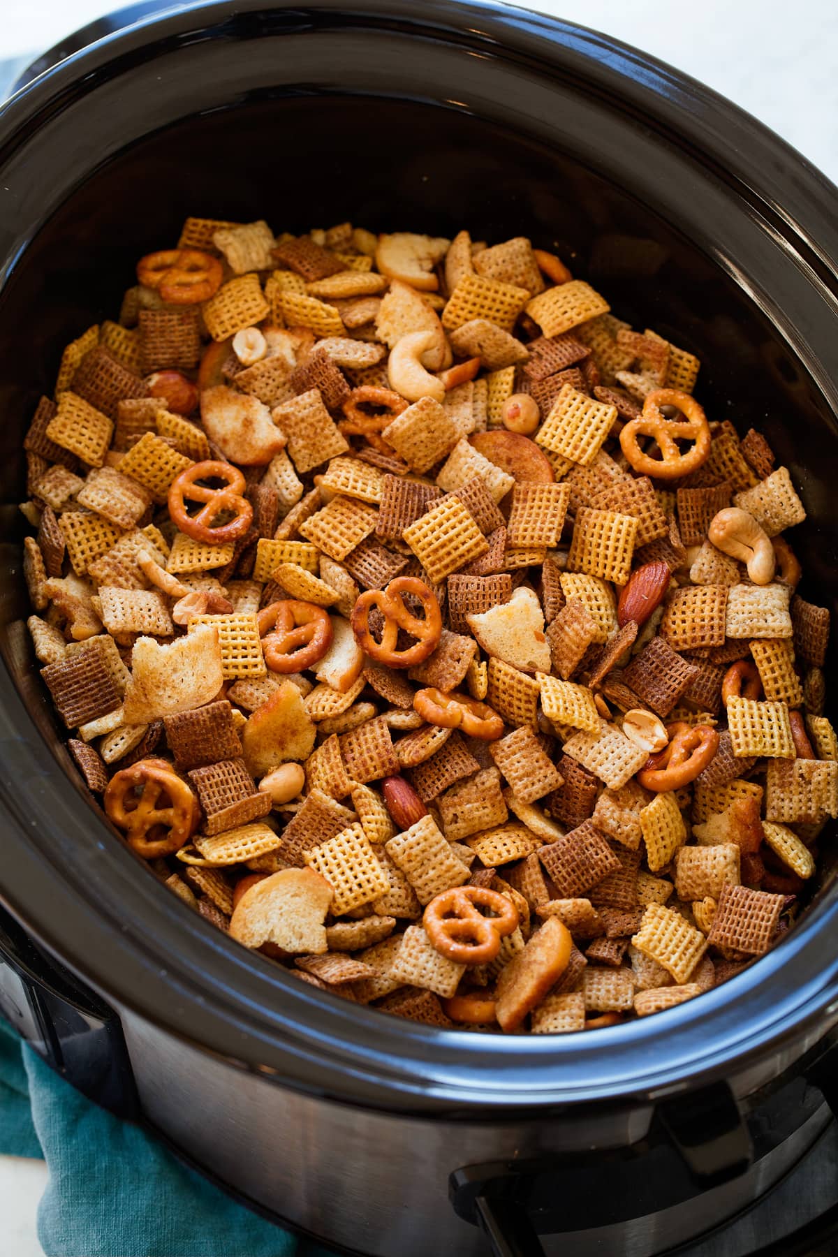 Chex Mix in a slow cooker shown after cooking.