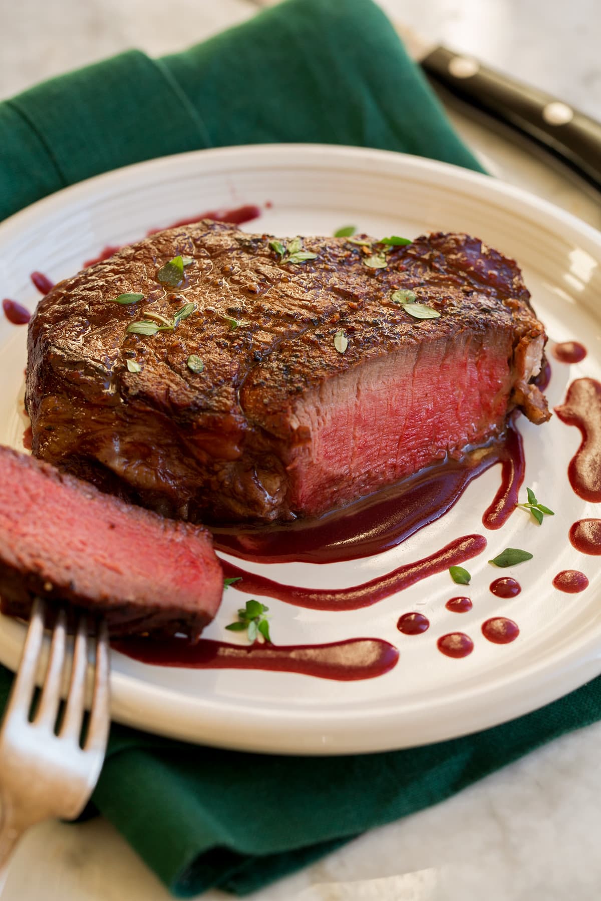Filet Mignon on a serving plate with red wine sauce.