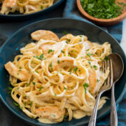 Chicken alfredo in a blue pasta bowl.