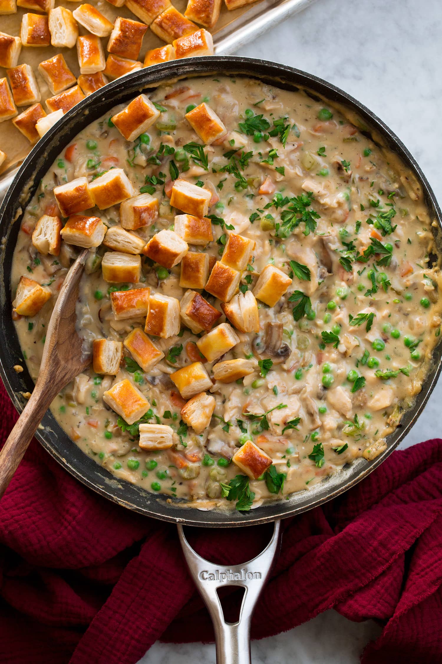 Chicken pot pie in a skillet with golden brown baked puff pastry pieces.