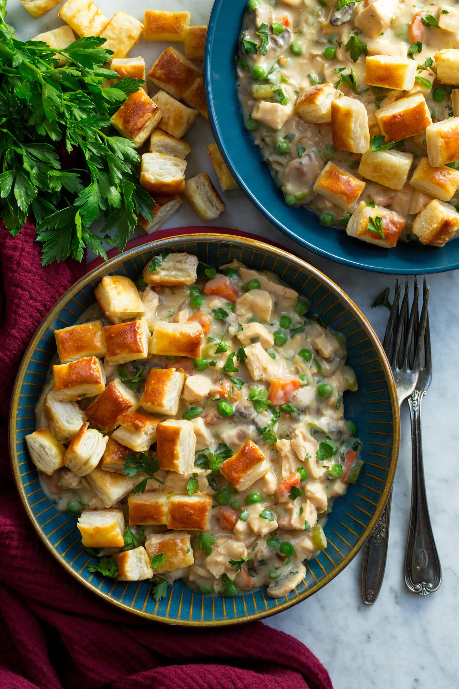 Overhead photo of chicken pot pie servings in bowls with puff pastry pieces.