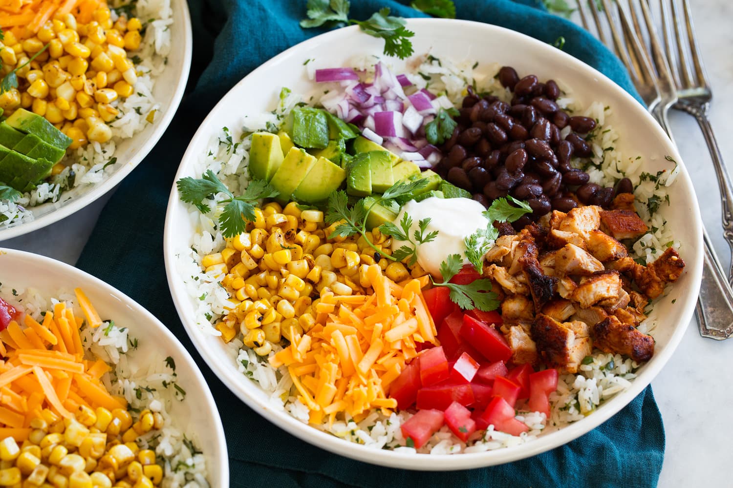 Completed burrito bowl with rice, chicken and toppings.