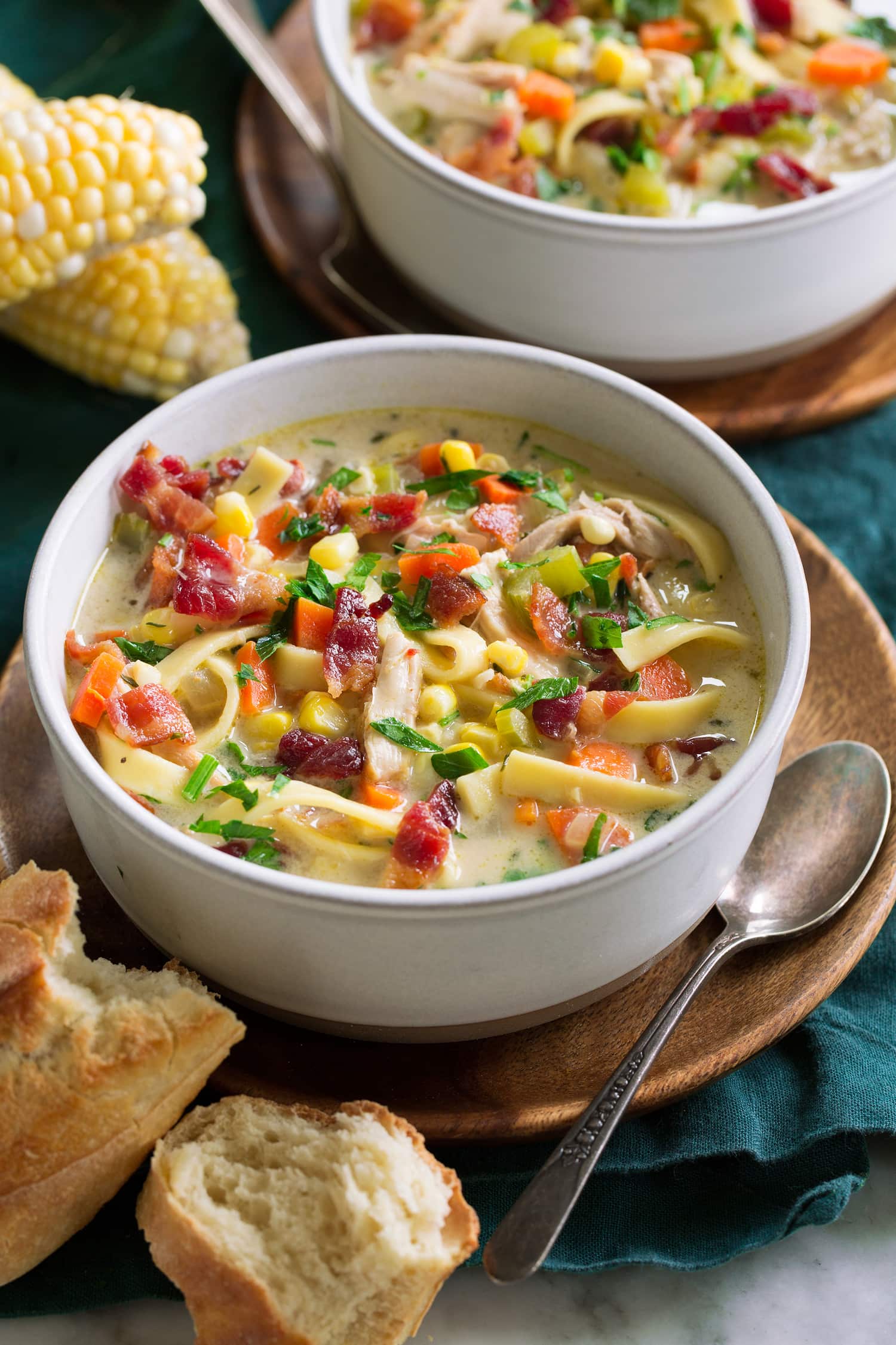Serving of chicken soup with corn in a white bowl