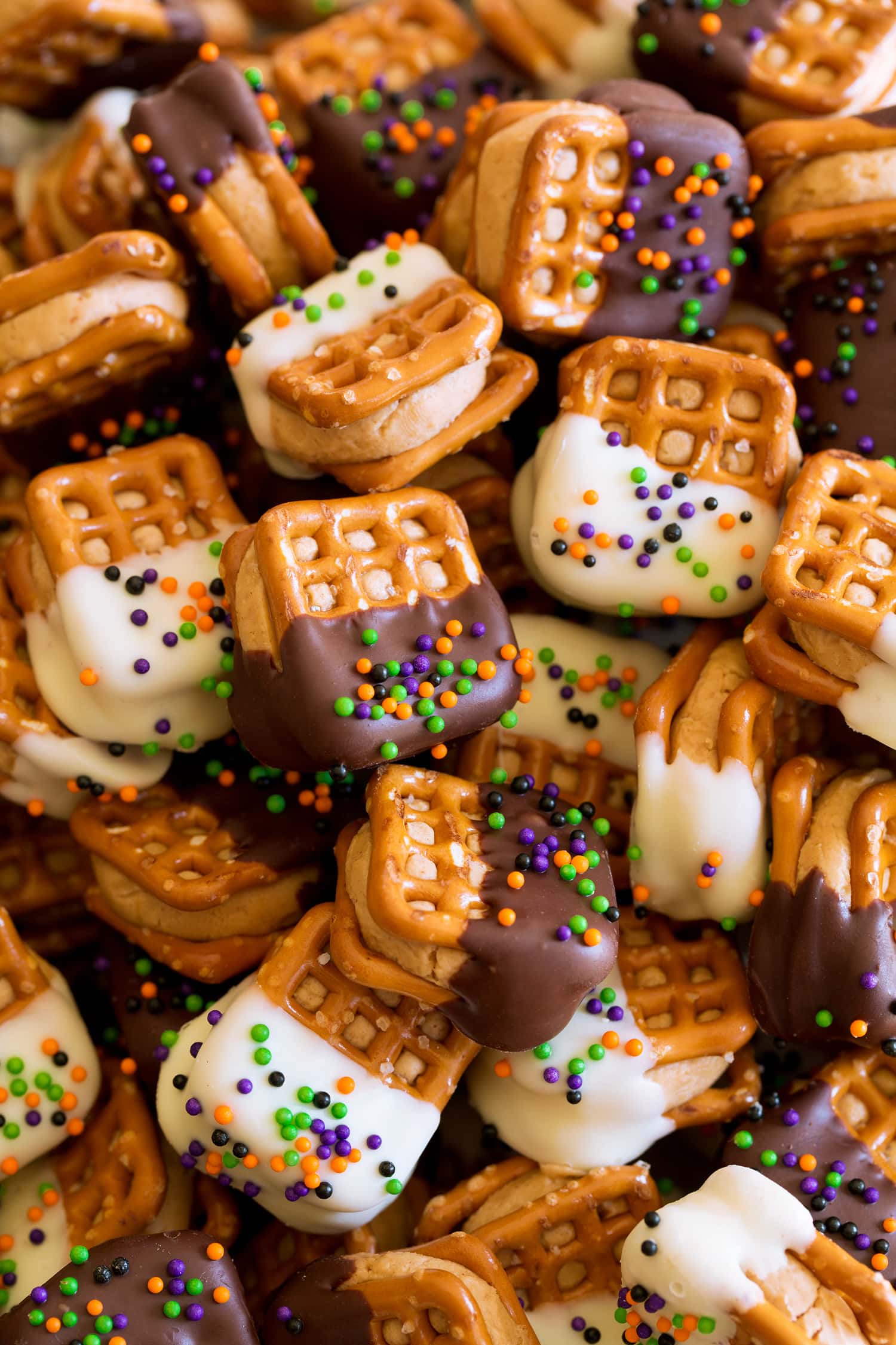Close up photo of pretzels stuffed with peanut butter filing and coated with chocolate and sprinkes.
