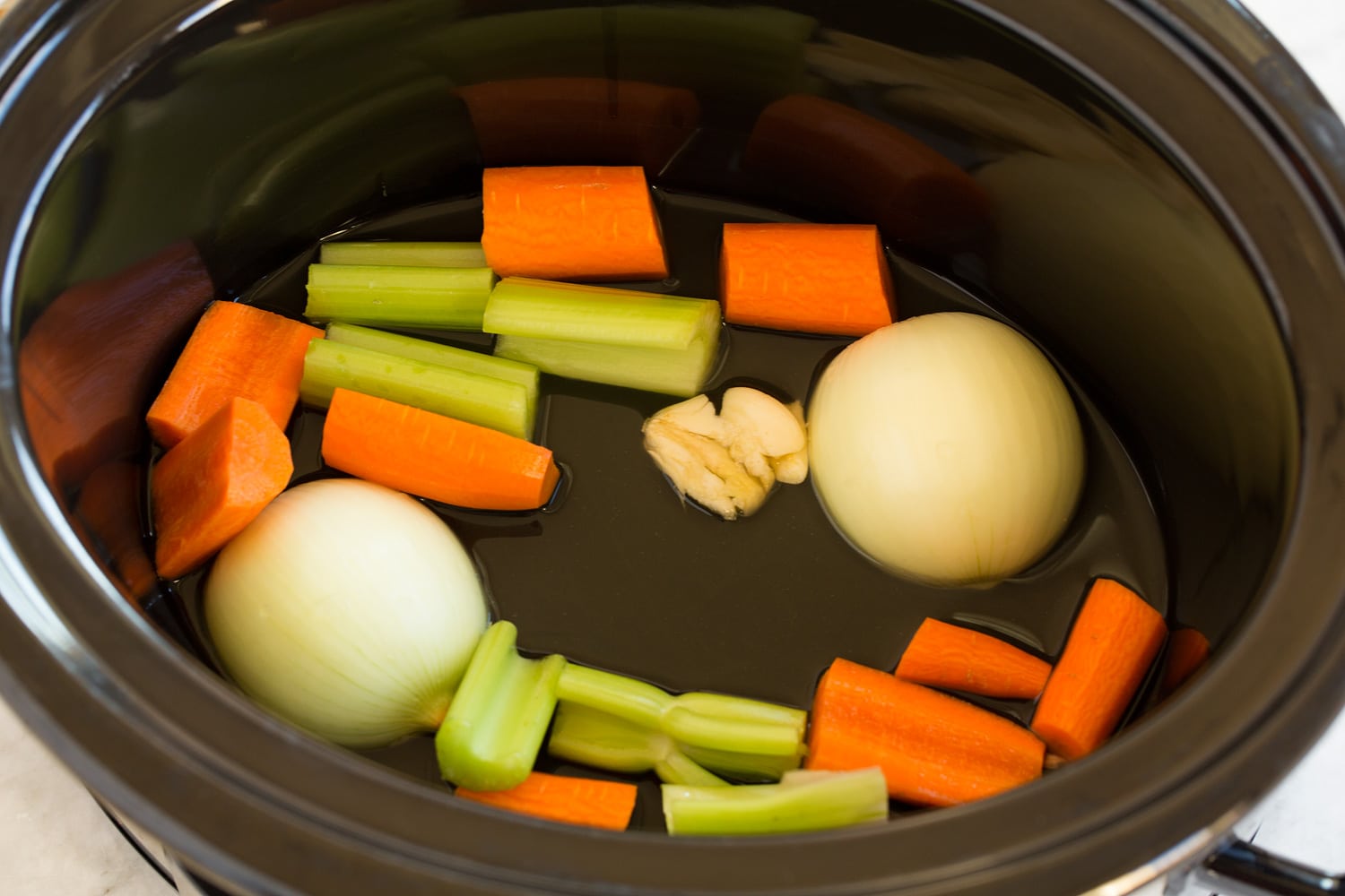 Fresh vegetables for turkey gravy in slow cooker.