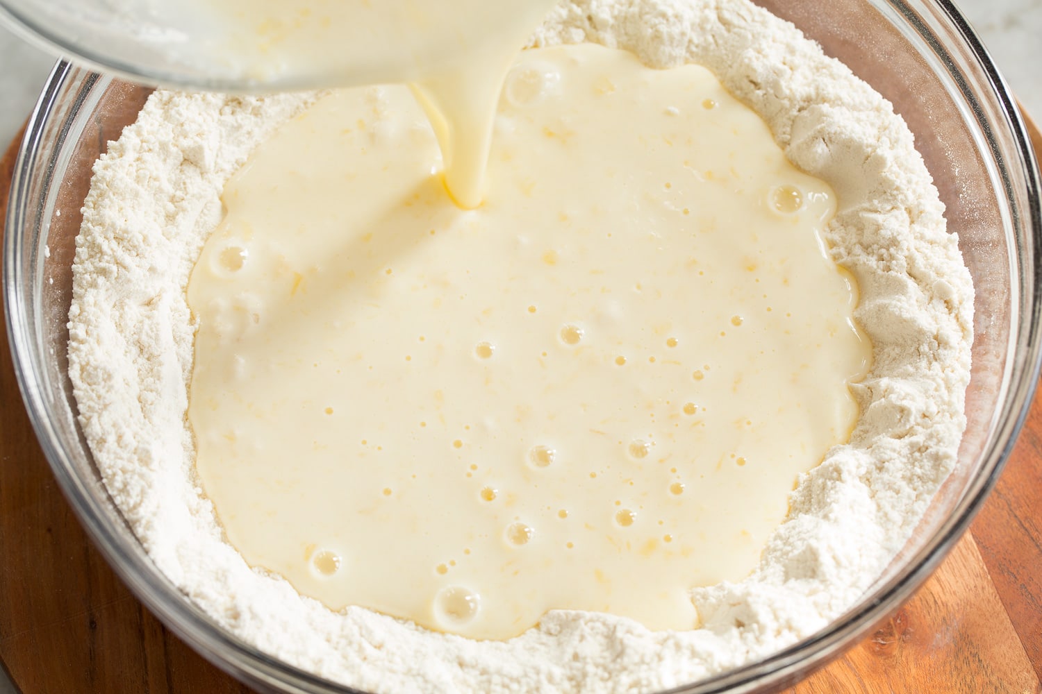 Pouring wet mixture into dry mixture for homemade pancake mix.