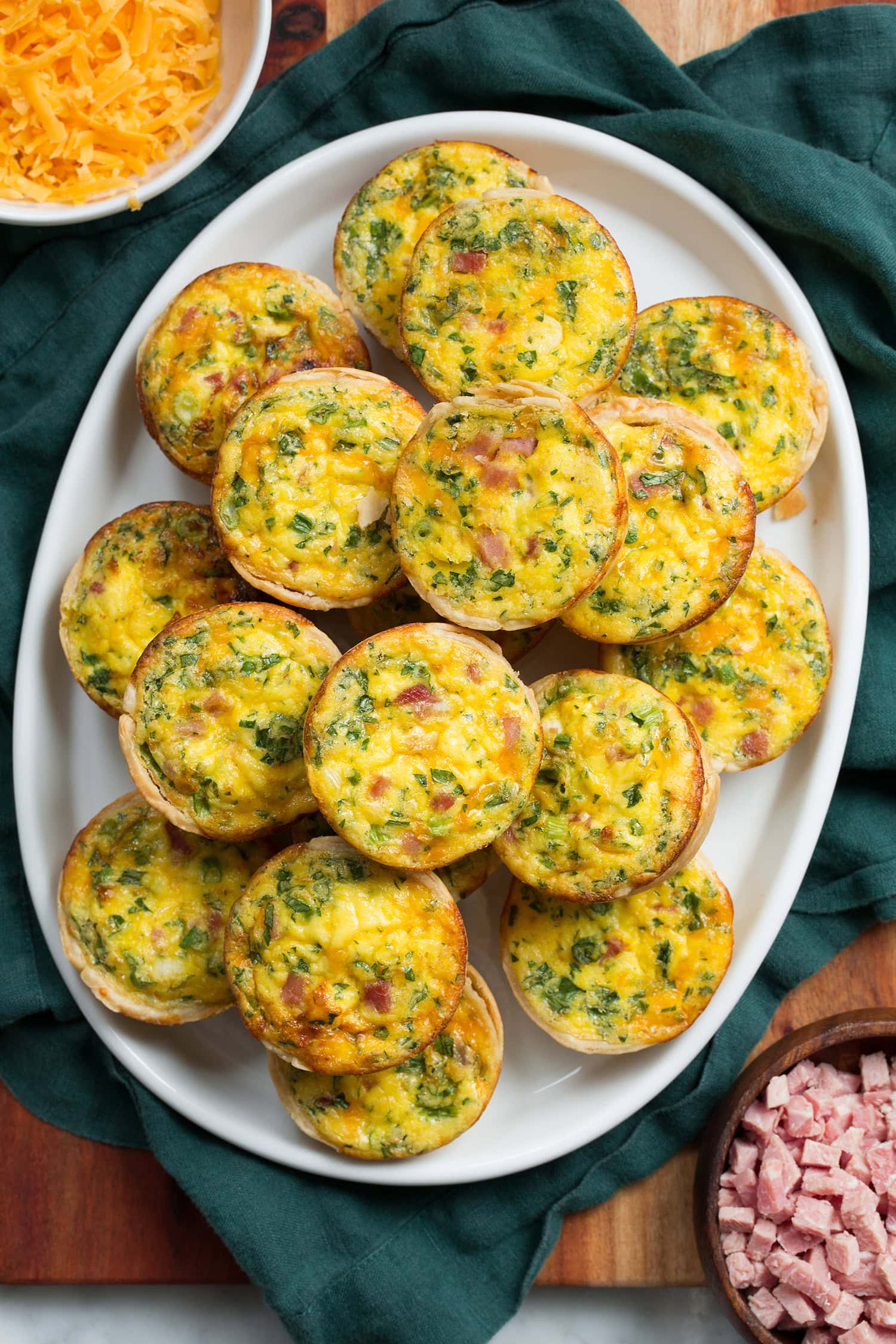 Overhead photo of mini egg quiche with ham and herb fillings.