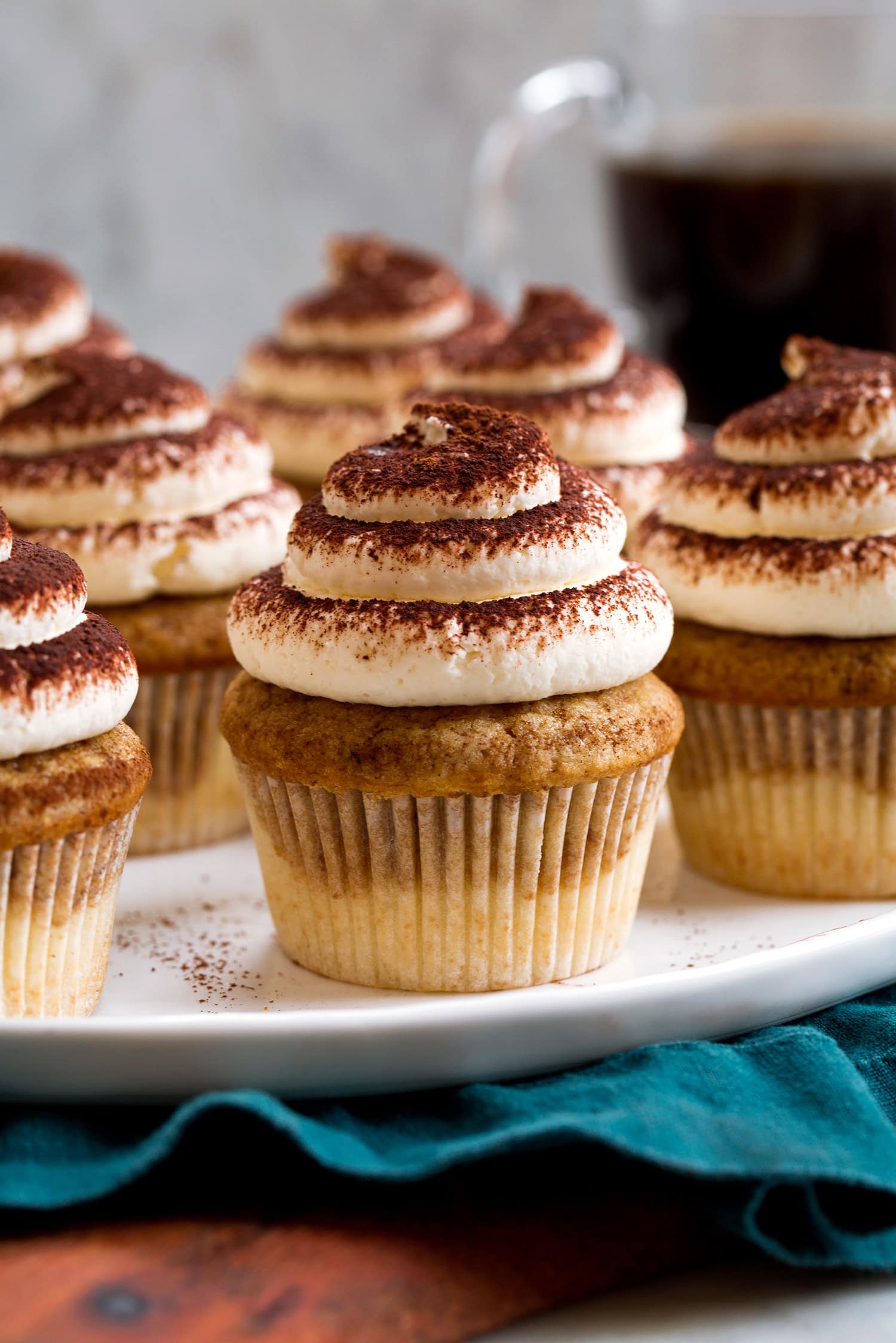 Close up photo of tiramisu cupcakes with mascarpone frosting dusted with cocoa and coffee vanilla cupcake.
