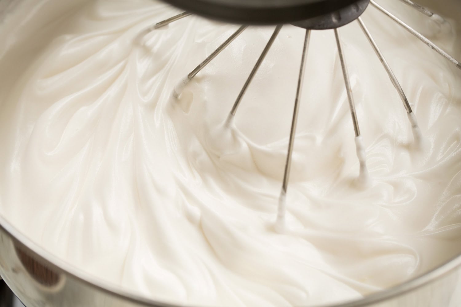 Whipped egg whites with sugar in stand mixer.