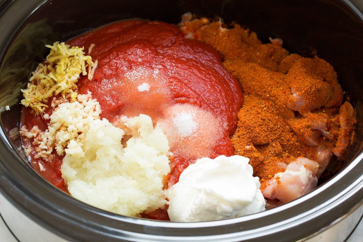 Tomato puree, onion, garlic, ginger, and yogurt added to chicken mixture.