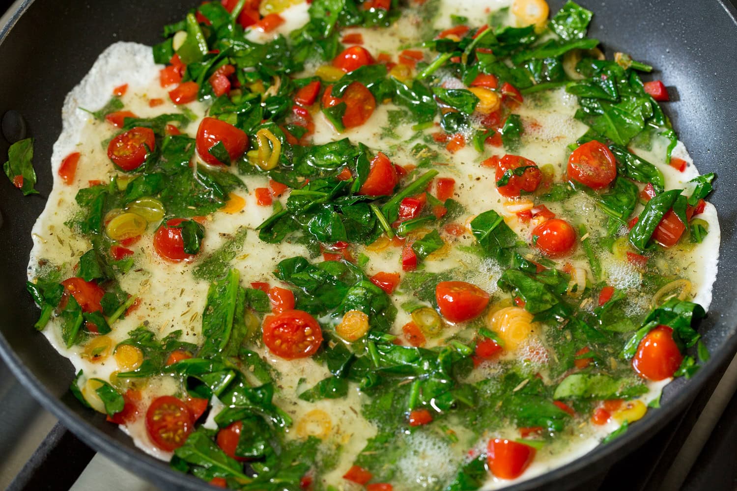 Egg whites added to sauteed veggies in skillet.
