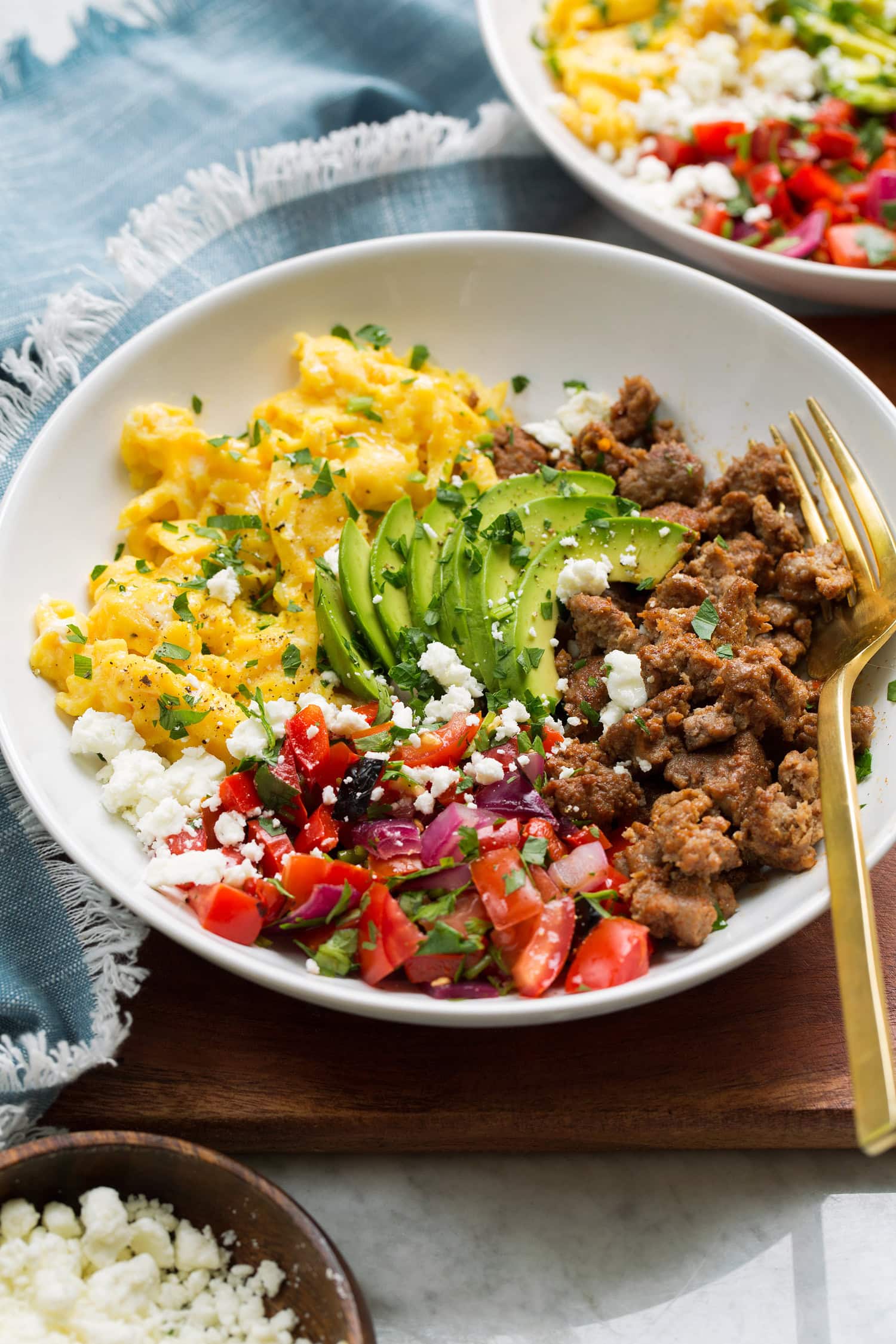 Breakfast bowl made with turkey sausage, scrambled eggs, pico, avocado and feta.