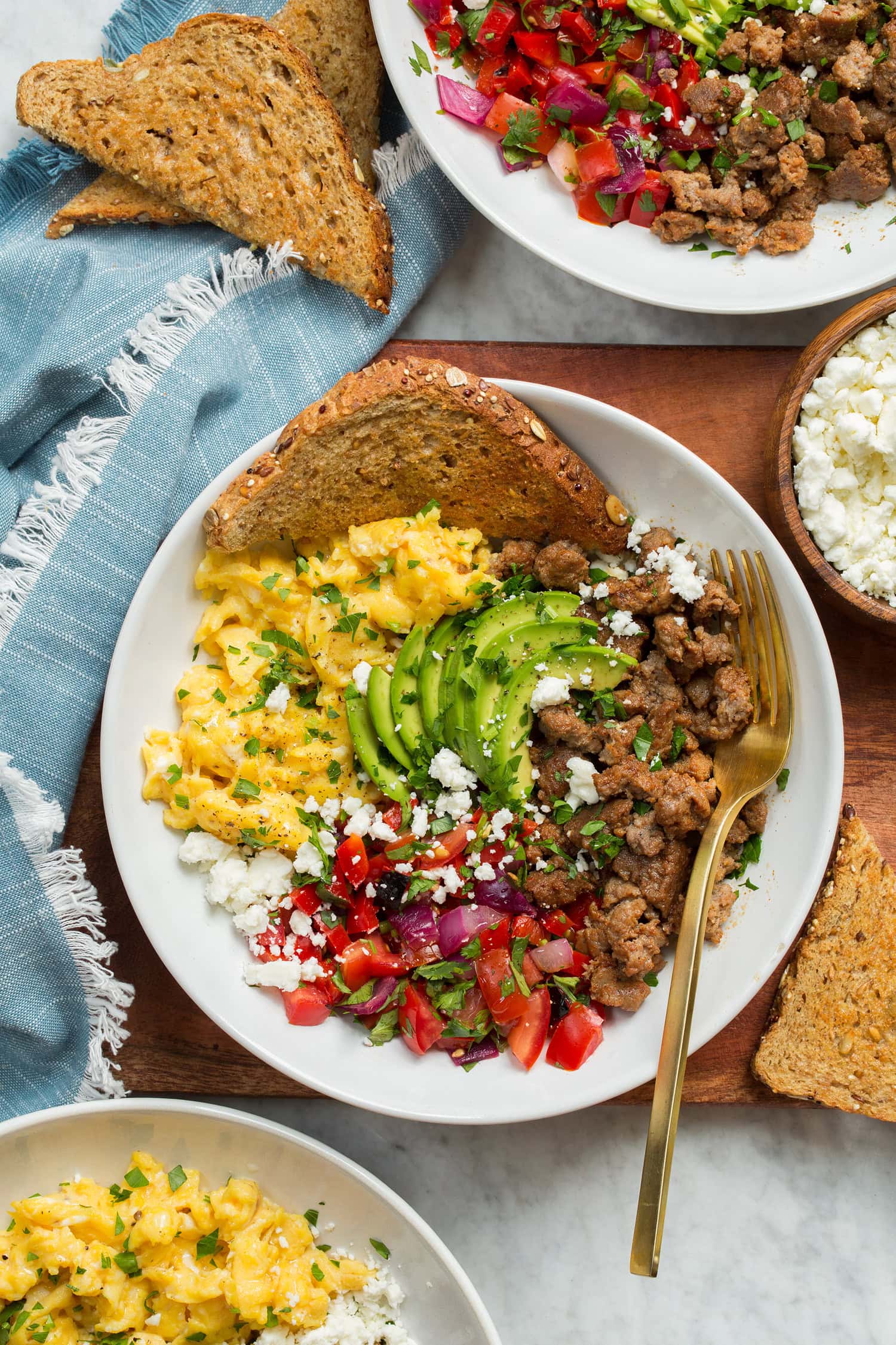 Overhead photo of breakfast bowl on a wooden tray with a blue cloth to the side.